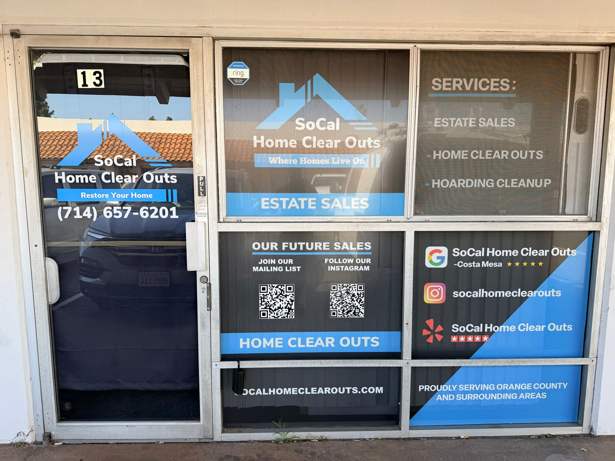 Front exterior of a storefront with large glass windows and doors displaying SoCal Home Clear Outts branding, services text, QR codes, and contact information.